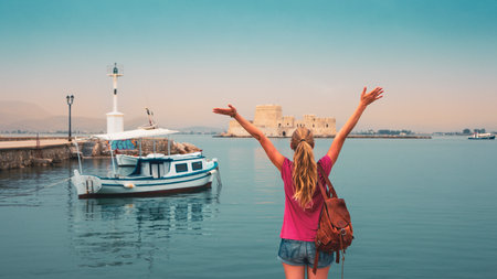 Traveler female enjoys The Bourtzi water castle and traditional fishing boat in Greece, Nafplio, Peloponneseの写真素材