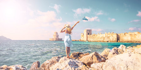 Happy traveler woman in Greece- The Bourtzi tower in Methoni Venetian Fortress in Peloponnese,...