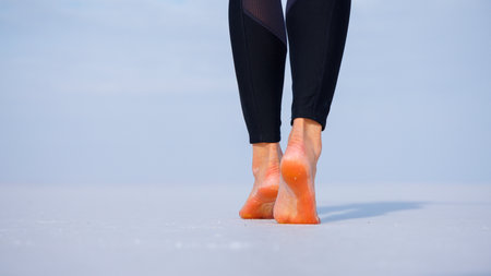 close up of woman feet- Woman walking barefoot on salt flats lake