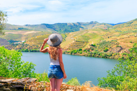 Woman tourist enjoying panoramic view of Douro valley in Portugalの写真素材
