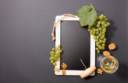 Top View of Grapes and White Wine on Blackboard with Copy Space â Elegant Wine Tasting Conceptの写真素材
