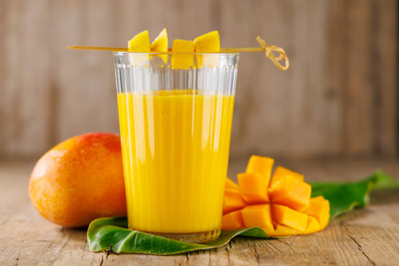 Glass of mango juice or smoothie. Ideal for diet, healthy eating, and vitamin-rich beverage conceptsの写真素材