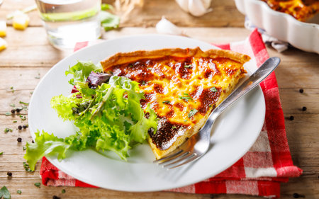 slice of quiche with salad on plateの写真素材