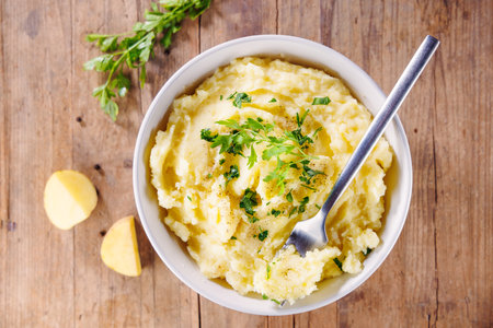 bowl of creamy mashed potatoes with butter and parsleyの写真素材