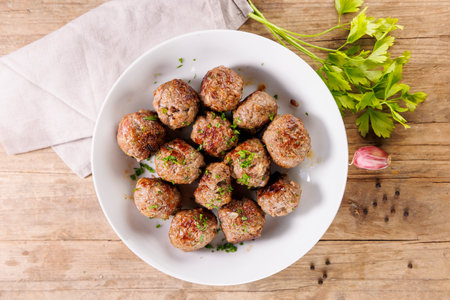 grilled meatballs with fresh herbs on wooden background, up highの写真素材