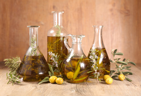 assorted of different bottles with olive oil, tree branch and rosemaryの写真素材