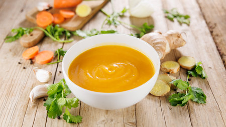 bowl of vegetable soup on wooden tableの写真素材