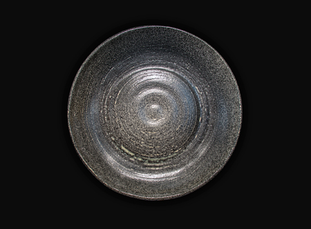 Ceramic flat plate on black background- top viewの写真素材