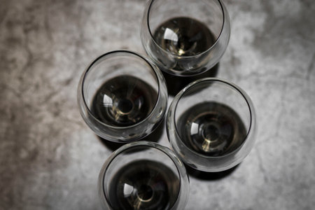 Wine glasses. They stand or lie on a gray background. They are filled with wine and coffee, cranberries.の写真素材