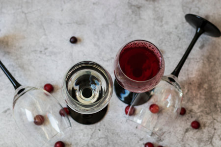 Wine glasses. They stand or lie on a gray background. They are filled with wine and coffee, cranberries.の写真素材