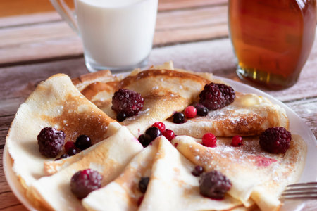 Homemade pancakes, delicious thin pancakes with berries and maple syrupの写真素材