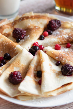 Homemade pancakes, delicious thin pancakes with berries and maple syrupの写真素材