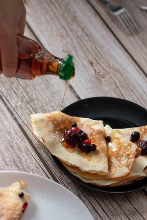 Homemade pancakes, delicious thin pancakes with berries and maple syrupの写真素材