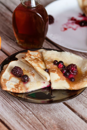 Homemade pancakes, delicious thin pancakes with berries and maple syrupの写真素材