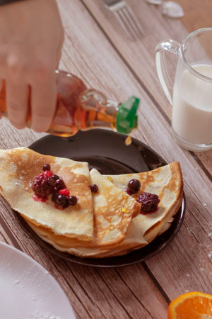 Homemade pancakes, delicious thin pancakes with berries and maple syrupの写真素材