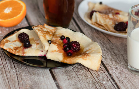 Homemade pancakes, delicious thin pancakes with berries and maple syrupの写真素材