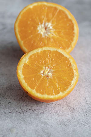 The orange halves are on the table. On a gray and white background.の写真素材