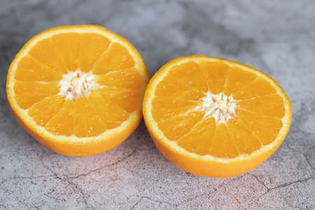 The orange halves are on the table. On a gray and white background.の写真素材