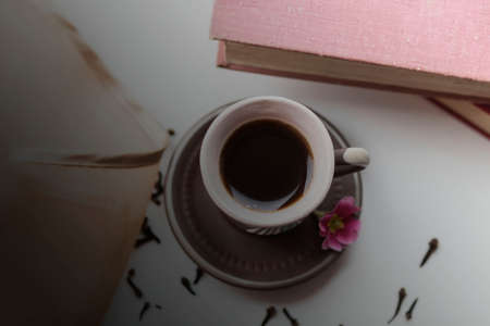 There is a beautiful coffee cup by the window. And there are books nearbyの写真素材