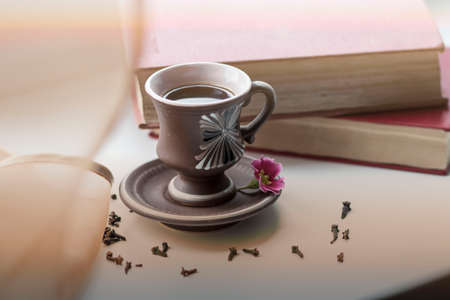 There is a beautiful coffee cup by the window. And there are books nearbyの写真素材