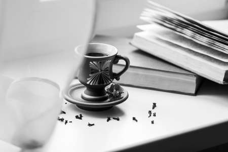 There is a beautiful coffee cup by the window. And there are books nearbyの写真素材