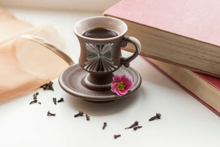 There is a beautiful coffee cup by the window. And there are books nearbyの写真素材