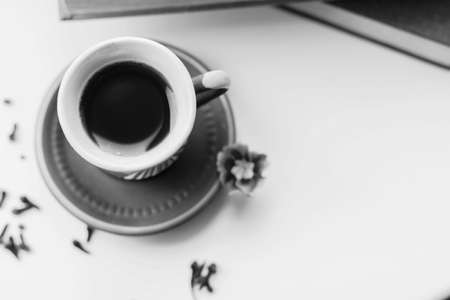 There is a beautiful coffee cup by the window. And there are books nearbyの写真素材