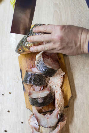 Fish. There is a raw fish cut into pieces on the kitchen board. And the whole thing.の写真素材