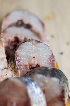 Fish. There is a raw fish cut into pieces on the kitchen board. And the whole thing.