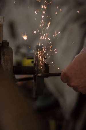 metalworking industry: working on a lathe with flying sparks. Latheの写真素材