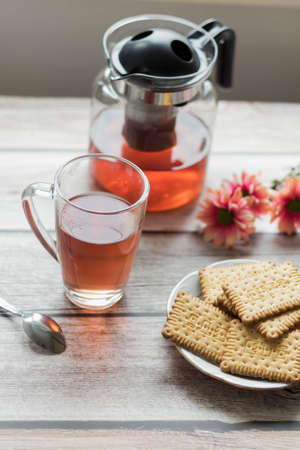 Morning tea is on the table. Flowers and biscuits lie nearby.の写真素材