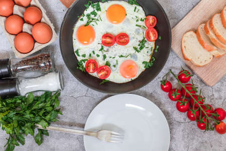 Fried eggs in a frying pan. On a concrete gray background. On the plateの写真素材