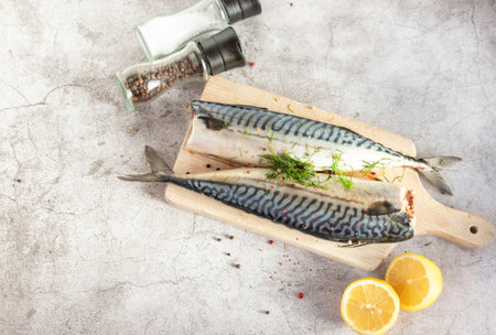 Fresh raw mackerel fish. On a gray background. Raw fish with lemon and dressingsの写真素材