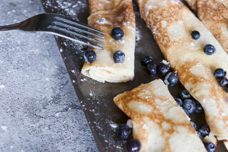 Homemade pancakes with blueberries. On gray plates and concrete background