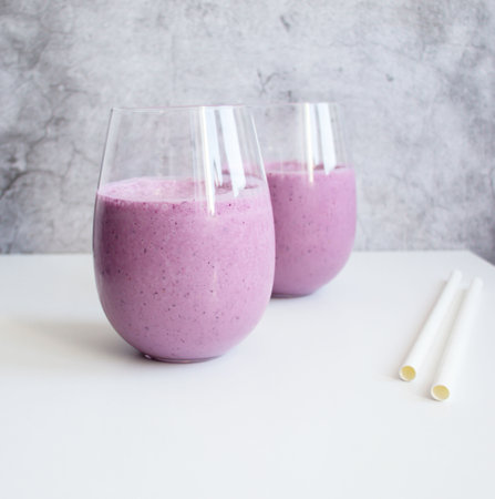 Smoothies with blueberries in a glass on a gray backgroundの写真素材