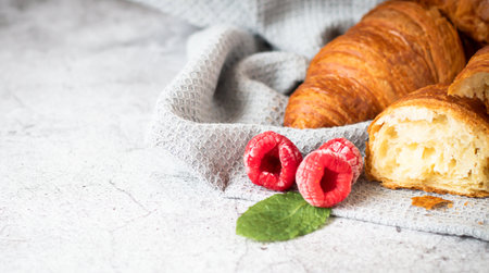 Fresh croissants with raspberries and mint on a white backgroundの写真素材