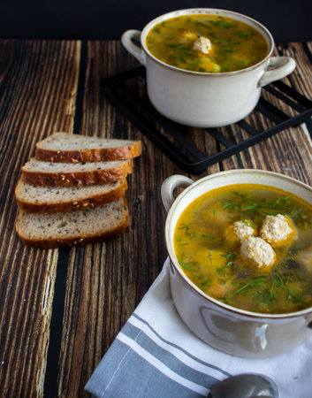 Chicken soup with meatballs and dill on a dark wooden backgroundの写真素材