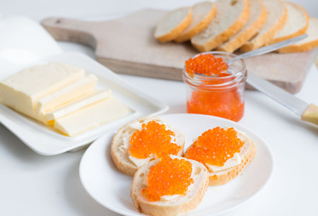 Sandwiches with butter and red caviar on a white backgroundの写真素材