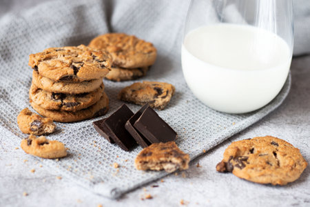 Chocolate chip cookies and a glass of milk on a linen napkinの写真素材