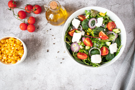 Healthy salad with arugula, tomatoes, feta cheese and red onion in a bowlの写真素材