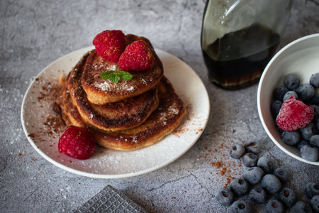 Pancakes with raspberries and blueberries on a gray background