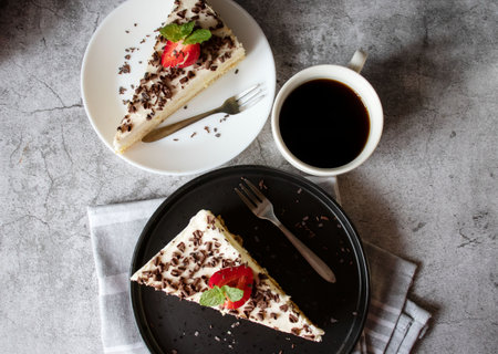 Piece of cheesecake with chocolate and cup of coffee, top view