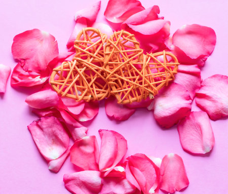 Rose petals and heart on a pink background. Valentine's dayの写真素材