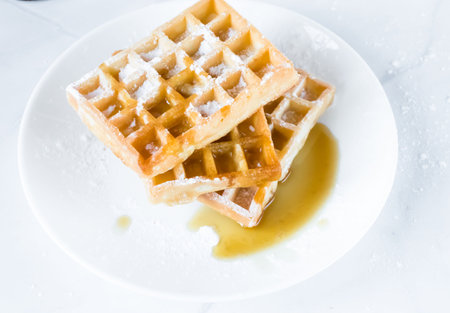 Waffle on white plate with honey and ice cream - soft focus point