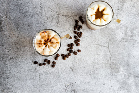 Coffee latte with whipped cream and coffee beans on concrete backgroundの写真素材