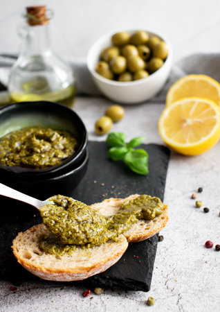 Homemade pesto sauce with olives on a stone background. selective focus.