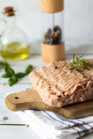 Raw tuna fish on a cutting board with herbs and olive oil.