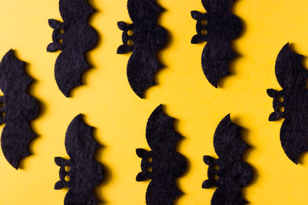 Silhouettes of black ghosts on a yellow background. Halloween concept.