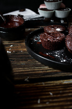 Chocolate muffins on a black plate on a dark wooden backgroundの写真素材