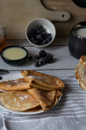 Pancakes with blueberries and honey on a rustic wooden table